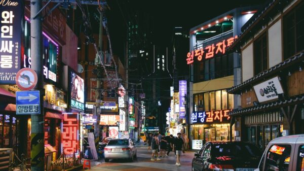 a busy city street at night with neon signs