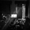 a black and white photo of people in a dark room