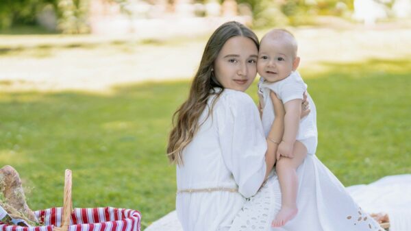 a woman in a white dress holding a baby