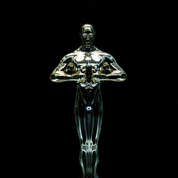 A golden trophy statue isolated on a black background symbolizing achievement and victory.