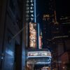A vibrant night view of Broadway Theater in New York City featuring West Side Story signage.