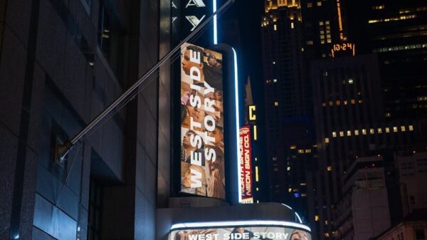 A vibrant night view of Broadway Theater in New York City featuring West Side Story signage.