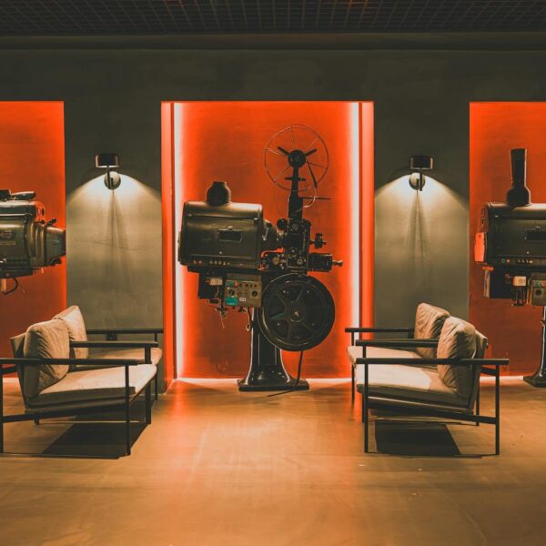 A cozy retro cinema room showcasing vintage film projectors and comfortable seating.