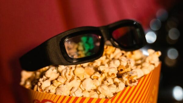 Close-up of popcorn and 3D glasses on cinema seats, ready for a movie experience.