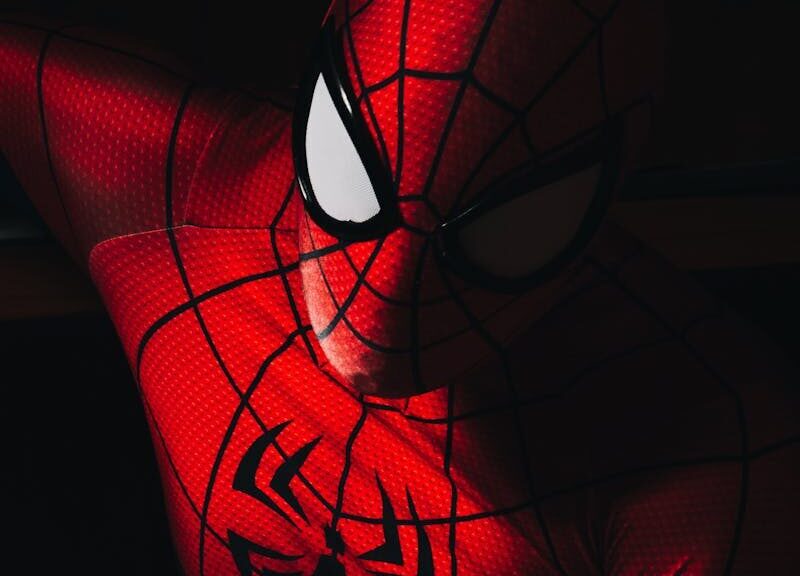 High contrast image of a person in a Spider-Man costume with dramatic lighting.