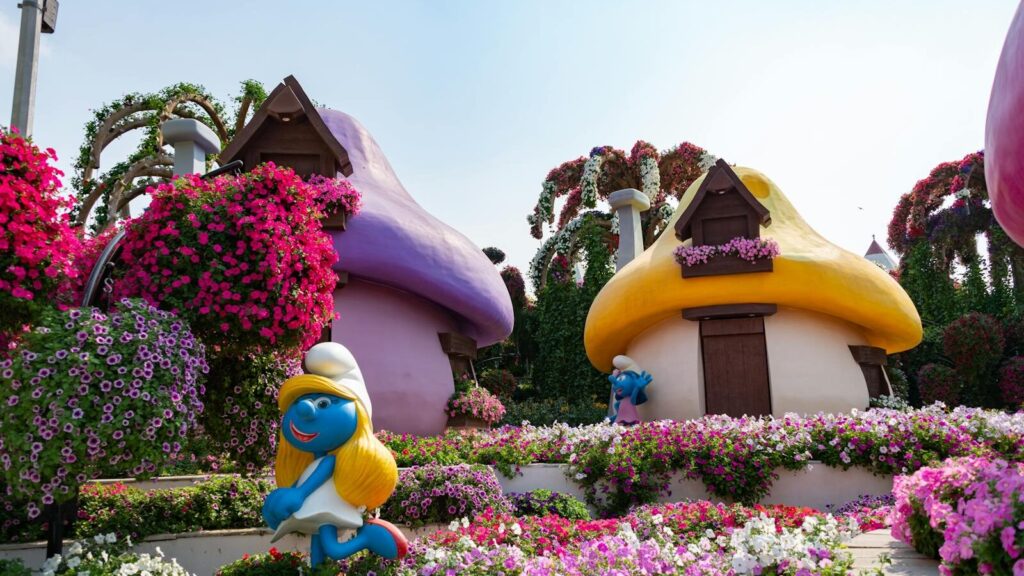 Colorful Smurf-themed garden with vibrant flowers at Dubai Miracle Garden, ideal travel spot.