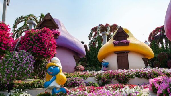 Colorful Smurf-themed garden with vibrant flowers at Dubai Miracle Garden, ideal travel spot.