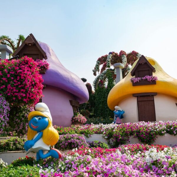 Colorful Smurf-themed garden with vibrant flowers at Dubai Miracle Garden, ideal travel spot.