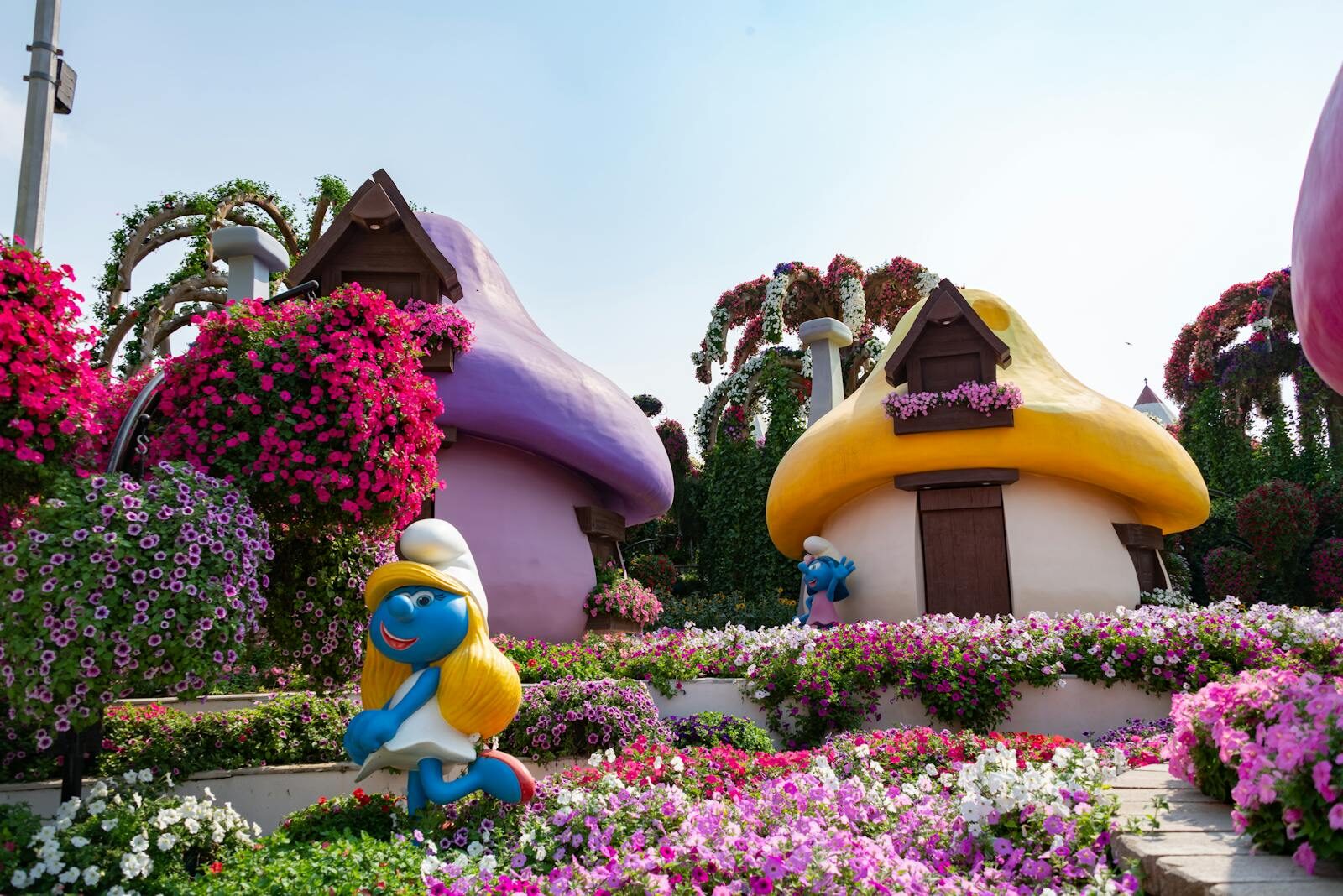 Colorful Smurf-themed garden with vibrant flowers at Dubai Miracle Garden, ideal travel spot.
