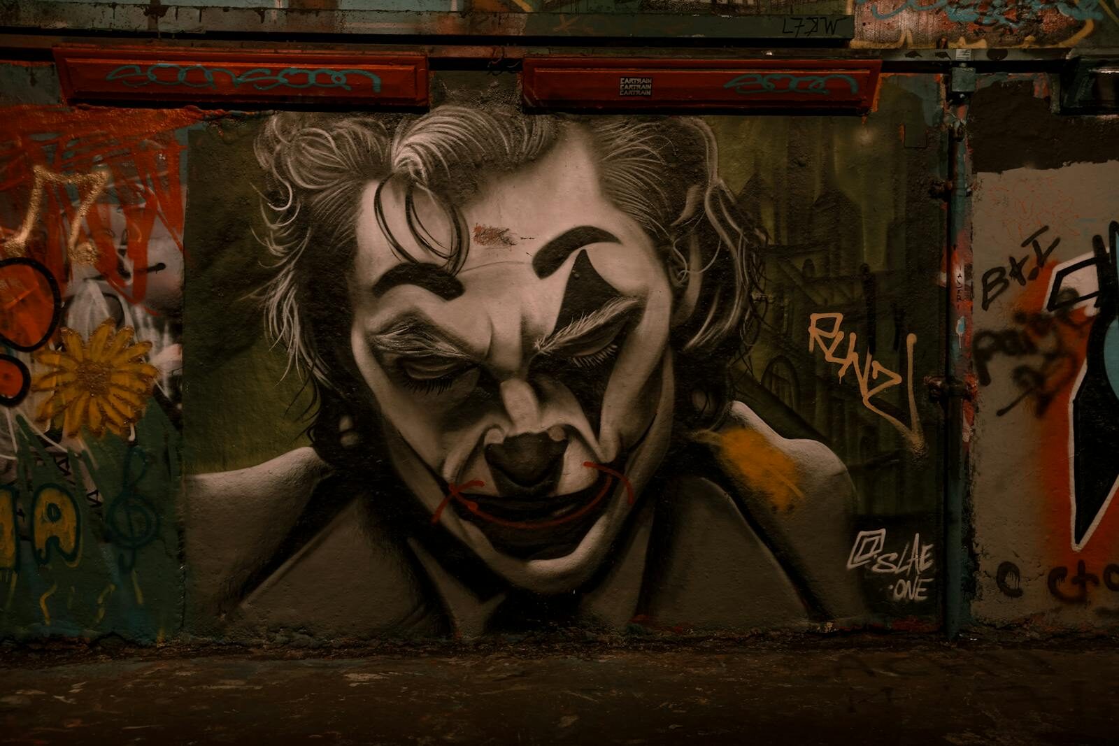 Dramatic Joker-themed graffiti in Leake Street Tunnel, London showcasing urban street art.