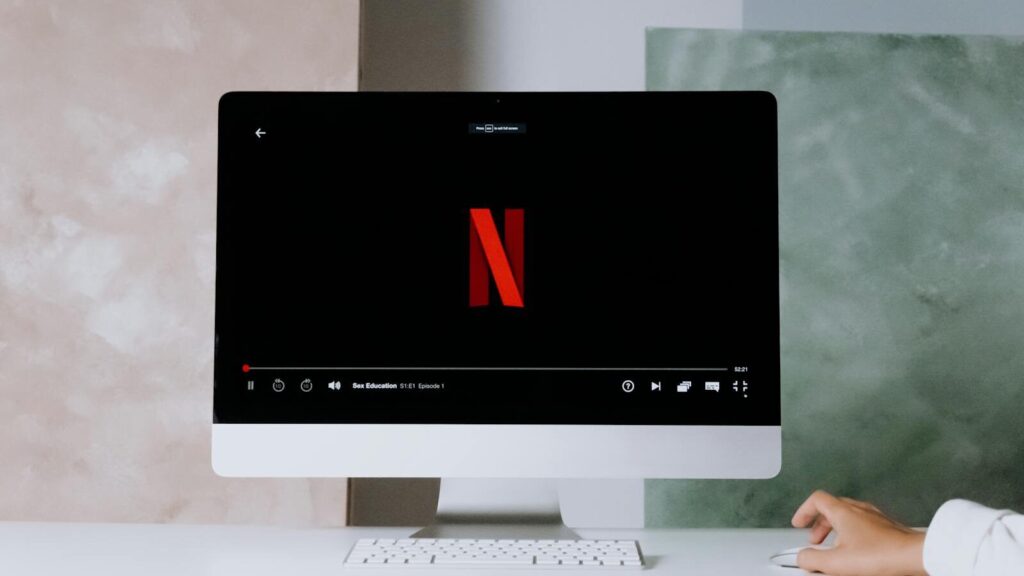 A minimalist workspace scene featuring a desktop displaying a streaming service, ideal for modern lifestyle themes.