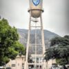 Iconic Warner Bros Studio water tower in Burbank, showcasing urban architecture against a mountain backdrop.