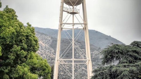 Iconic Warner Bros Studio water tower in Burbank, showcasing urban architecture against a mountain backdrop.