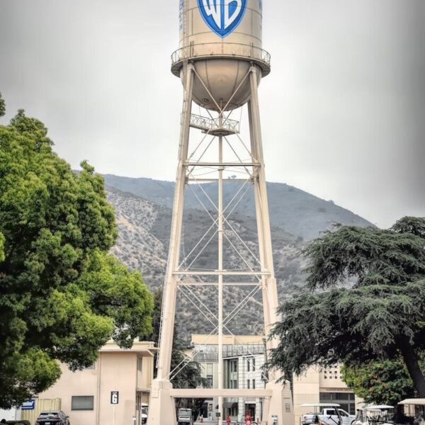 Iconic Warner Bros Studio water tower in Burbank, showcasing urban architecture against a mountain backdrop.