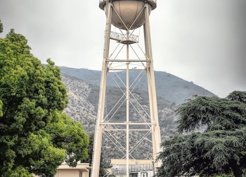Iconic Warner Bros Studio water tower in Burbank, showcasing urban architecture against a mountain backdrop.