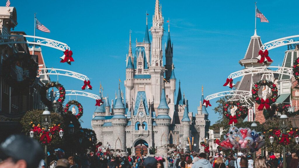 A busy day at Orlando's Magic Kingdom with crowds enjoying holiday decorations.