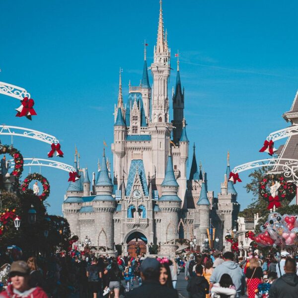 A busy day at Orlando's Magic Kingdom with crowds enjoying holiday decorations.