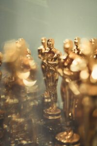 Close-up of multiple golden trophy statues resembling Oscars, symbolizing achievement.