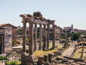 Aerial view of the historic Roman Forum ruins on a sunny day in Rome, Italy.