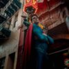 A superhero cosplayer poses in vibrant San Francisco Chinatown under neon lights.