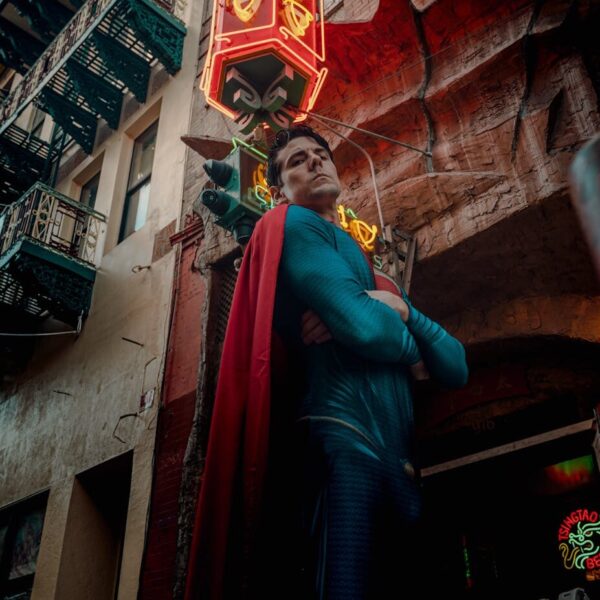 A superhero cosplayer poses in vibrant San Francisco Chinatown under neon lights.