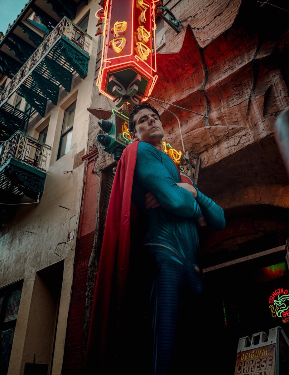 A superhero cosplayer poses in vibrant San Francisco Chinatown under neon lights.