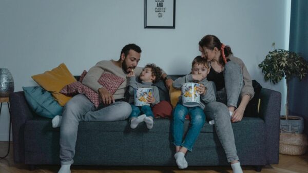 A family shares bonding time with popcorn on the sofa during movie night.