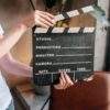 Close-up of hands holding a film slate board in an artistic indoor setting.