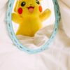 Adorable Pikachu plush reflected in a vintage mirror, adding a playful touch to decor.