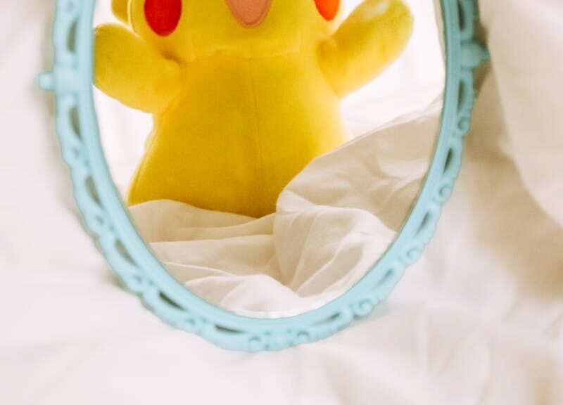 Adorable Pikachu plush reflected in a vintage mirror, adding a playful touch to decor.