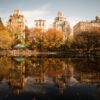 Stunning autumn view of Central Park with cityscape reflecting in the lake.