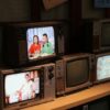 a bunch of tvs that are sitting on a shelf