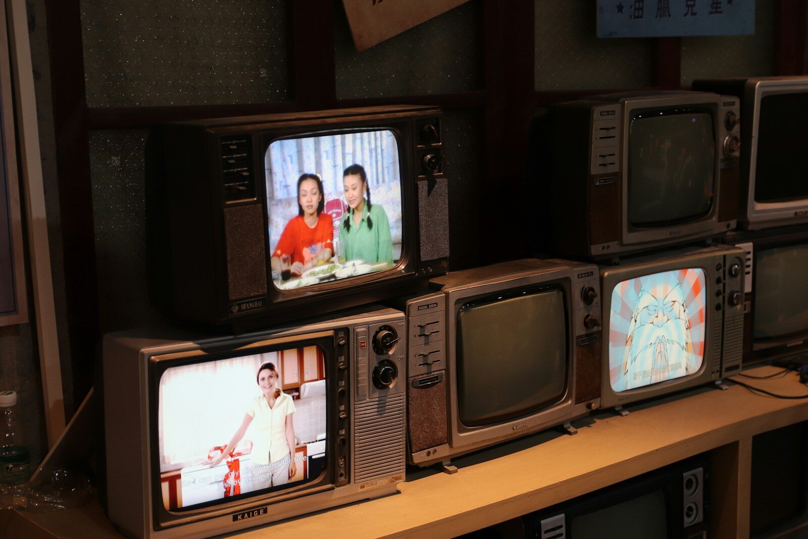 a bunch of tvs that are sitting on a shelf