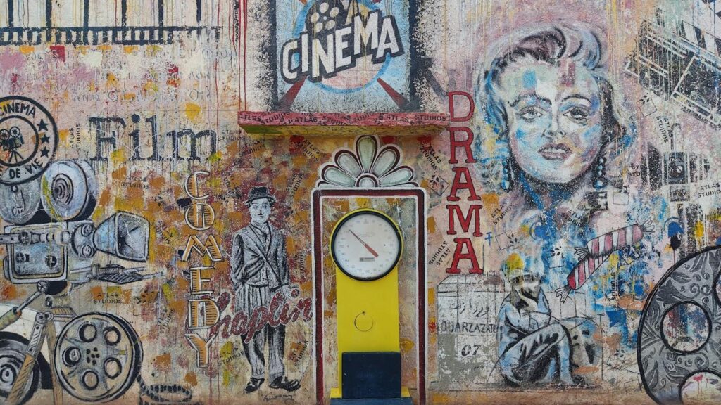 Colorful mural featuring cinematic themes in Ouarzazate, Morocco, with vintage design elements.