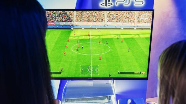 Two gamers playing FIFA on PS5 at a nighttime gaming event.