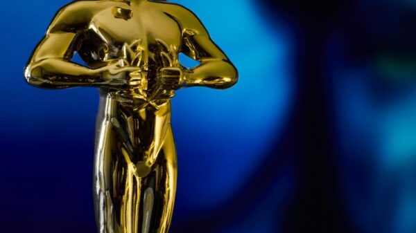A shining Oscar statuette, symbolizing achievement in the film industry, against a vibrant blue backdrop.