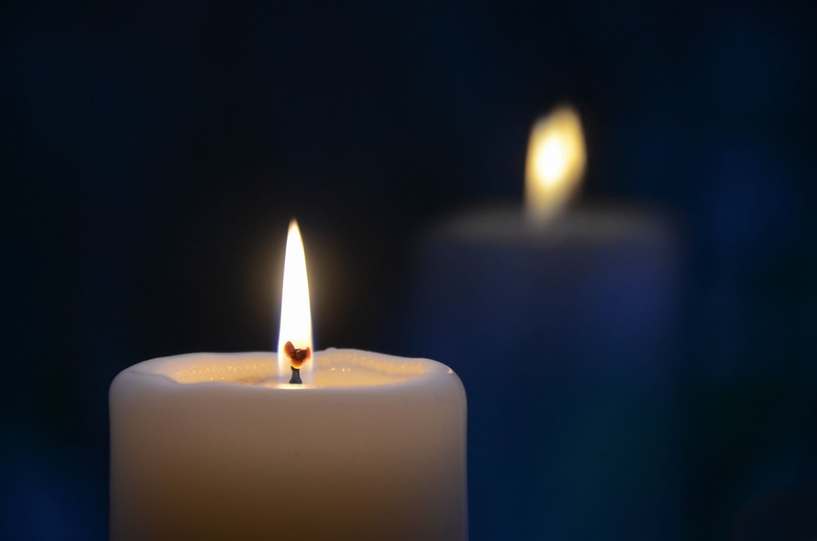 Close-up of a burning candle with a soft glow, creating a tranquil atmosphere.