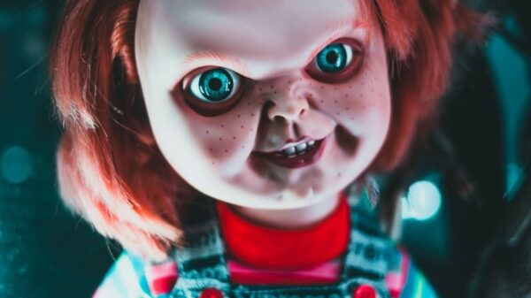 Creative design of doll with redhead and freckles on terrible face representing aggressive character at home