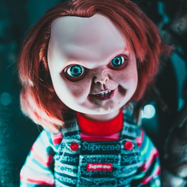 Creative design of doll with redhead and freckles on terrible face representing aggressive character at home