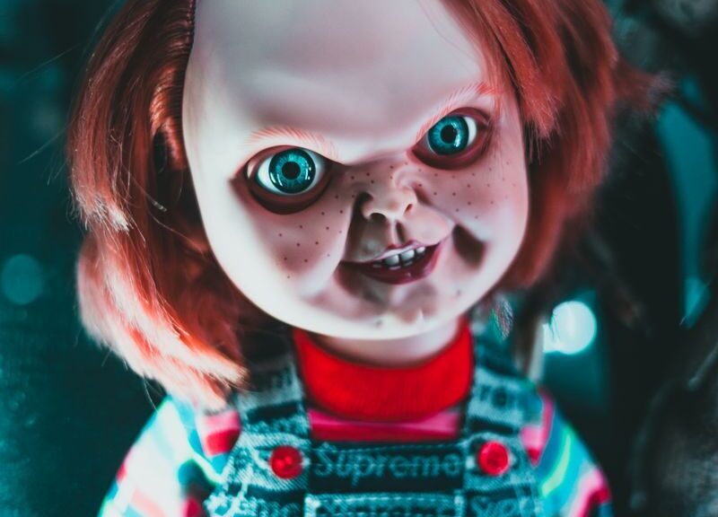 Creative design of doll with redhead and freckles on terrible face representing aggressive character at home