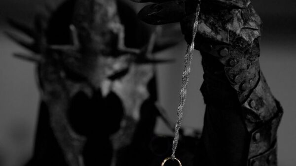 Mystical armored figure with a spiked helmet holding a mysterious ring in focus.