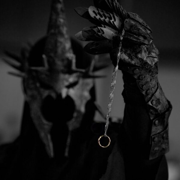 Mystical armored figure with a spiked helmet holding a mysterious ring in focus.