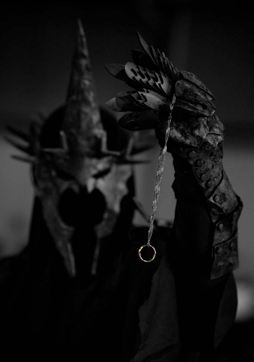 Mystical armored figure with a spiked helmet holding a mysterious ring in focus.