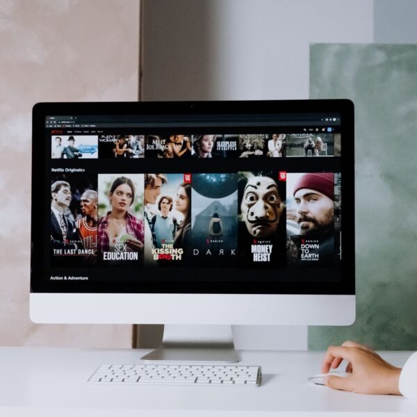 A modern workspace featuring a desktop screen displaying popular streaming series on Netflix.