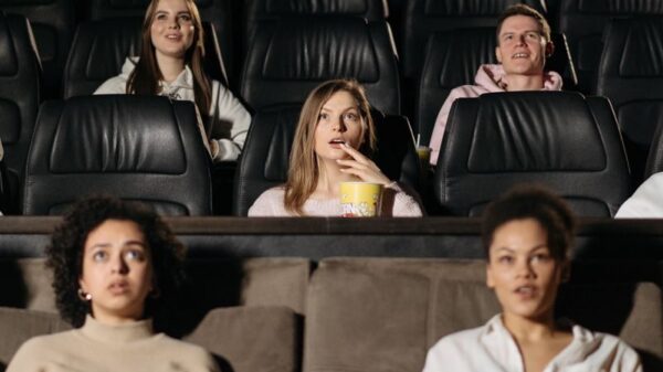 Audience watching film in theater, enjoying popcorn in a cozy setting.