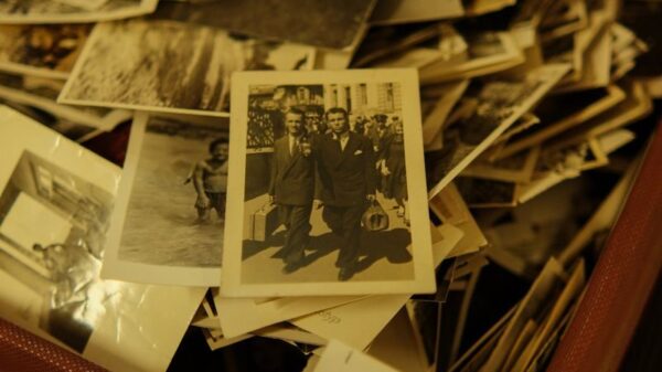 A collection of vintage black and white photographs in an antique suitcase.