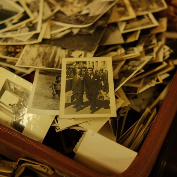 A collection of vintage black and white photographs in an antique suitcase.