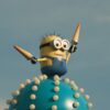 Vibrant Minion character statue atop a whimsical spiked orb under a clear blue sky.