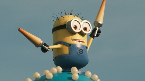 Vibrant Minion character statue atop a whimsical spiked orb under a clear blue sky.