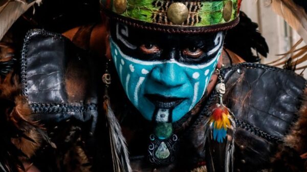 Vibrant tribal costume featuring face paint, feathers, and intricate details.